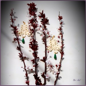 Large sand white ornamental cord earrings with opaque emerald and gold hardware 